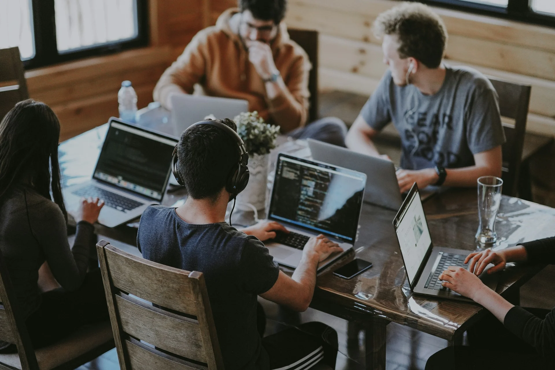 People collaborating around a table with laptops.