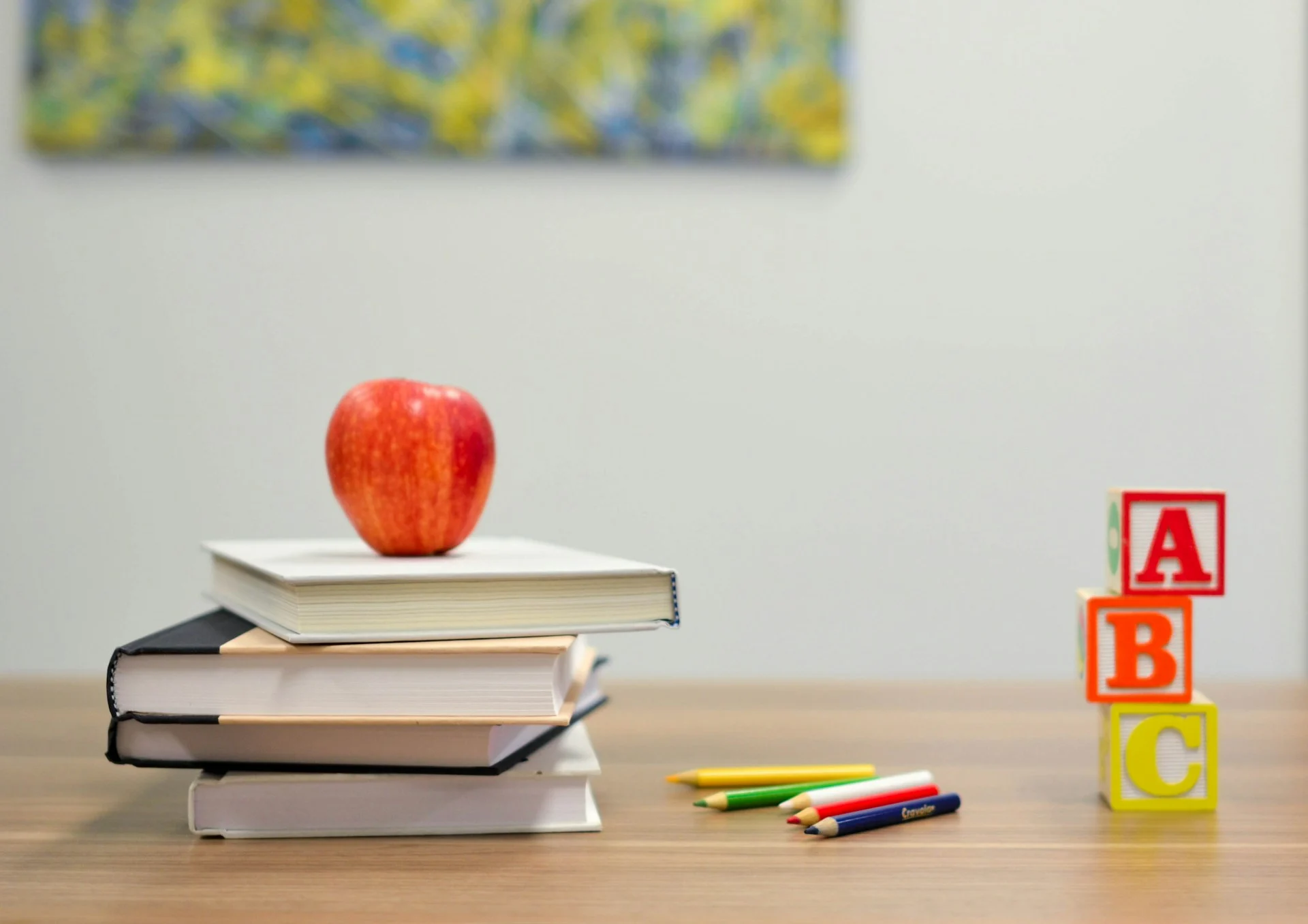 Books, an apple, pencils, and alphabet blocks.